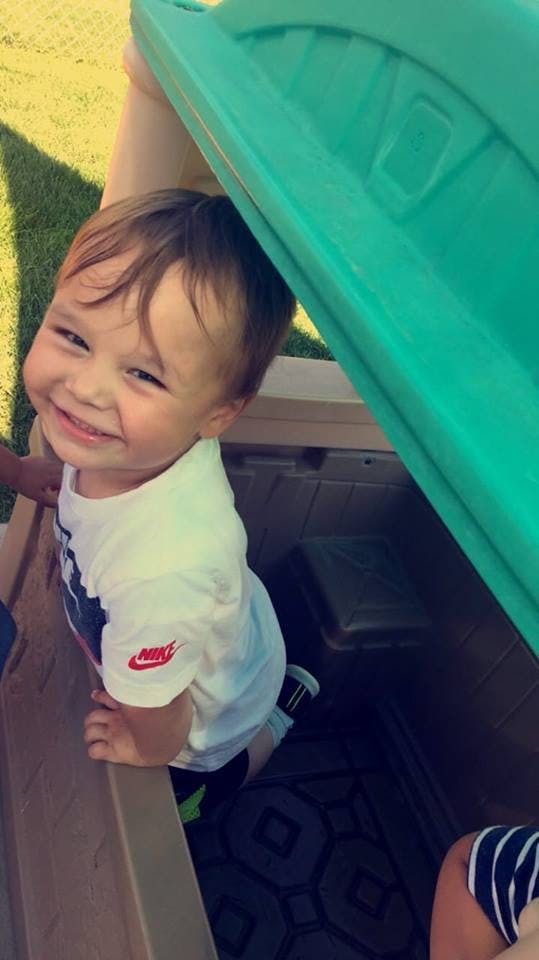 Child looking up from inside a play structure