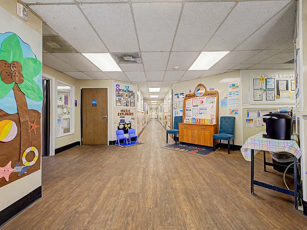 Long hallway with decorated walls, a parent center, and a welcome mat