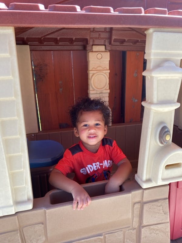 Child smiling inside a playhouse window