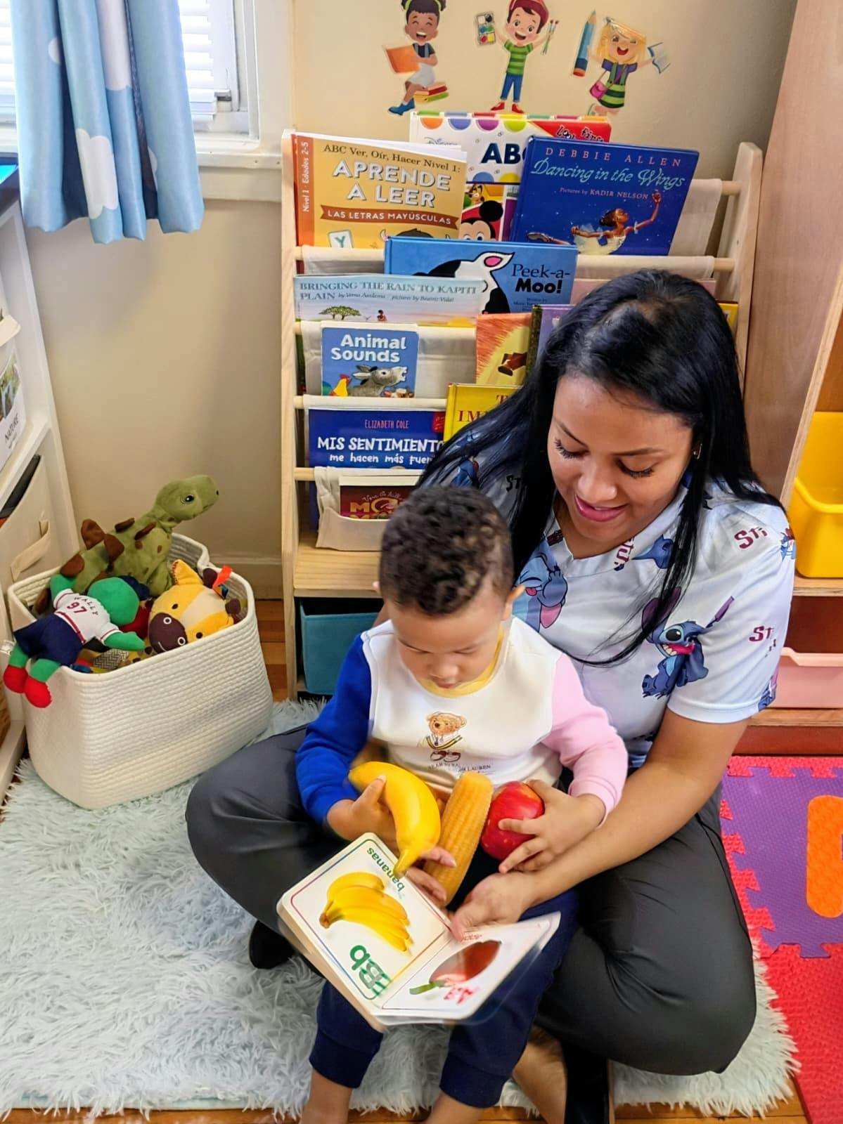 Person and child holding a book about bananas with toy fruit