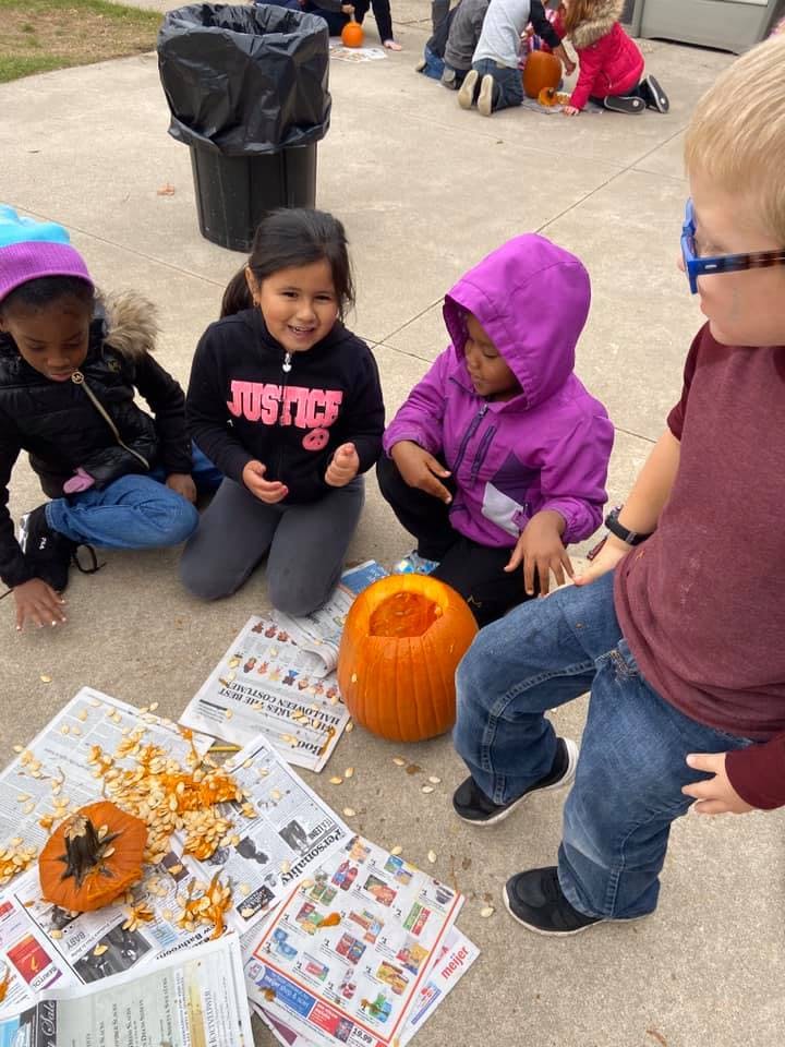Children carving pumpkins outdoors