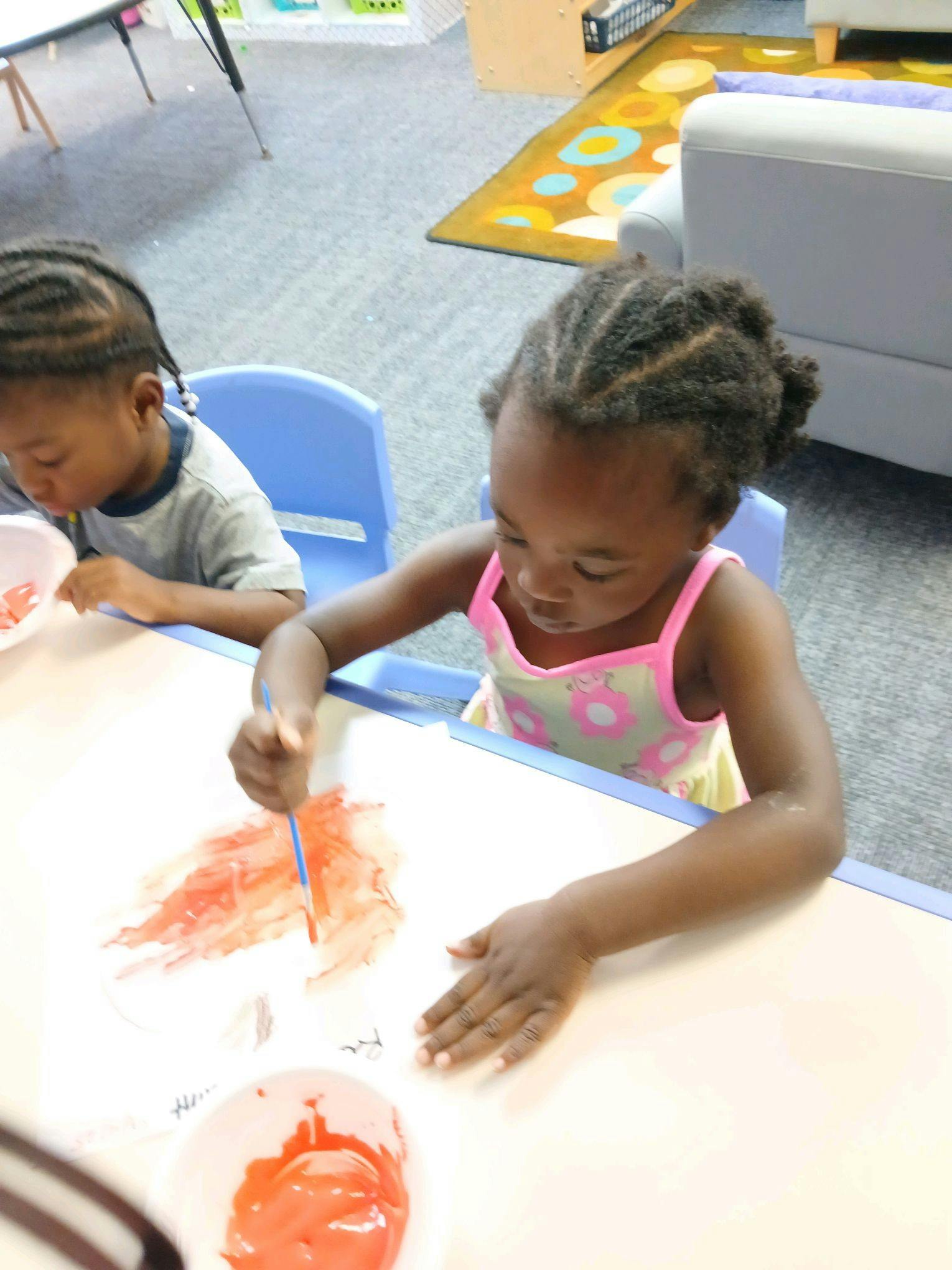 Child painting at a table in a classroom