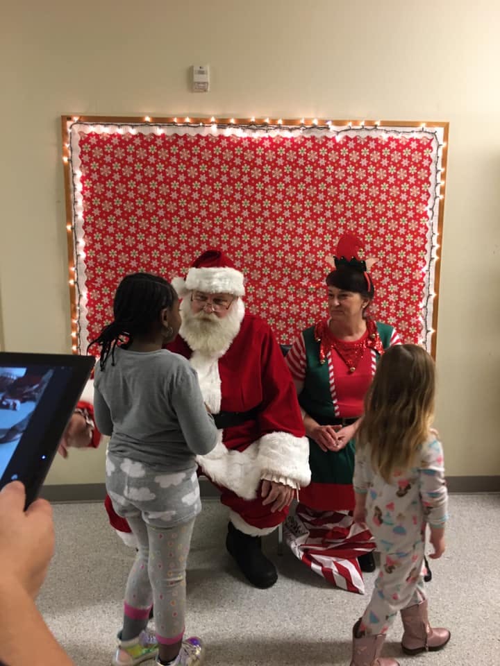 Santa Claus and an elf with two children