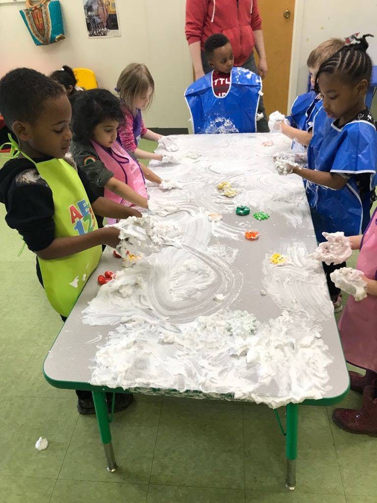 Children playing with shaving cream on a table