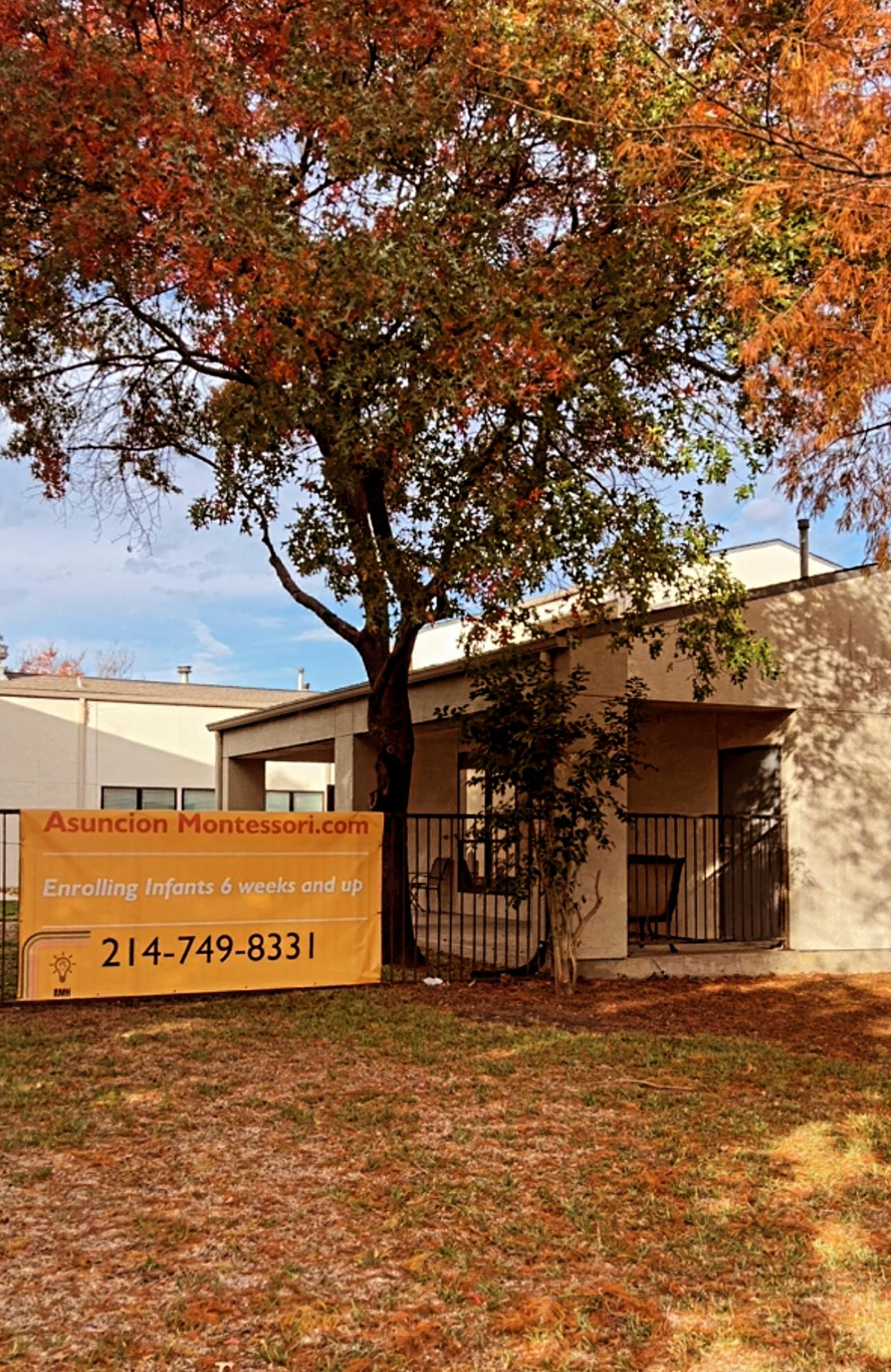 Building exterior with a tree and a sign for Asuncion Montessori