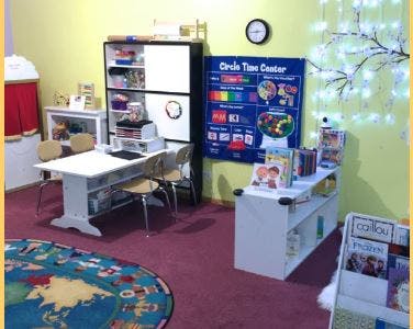 classroom with a table and chairs, shelves, and a "Circle Time Center" poster
