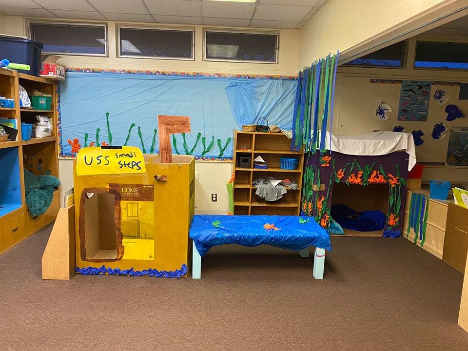 Classroom with play structures and a blue bulletin board