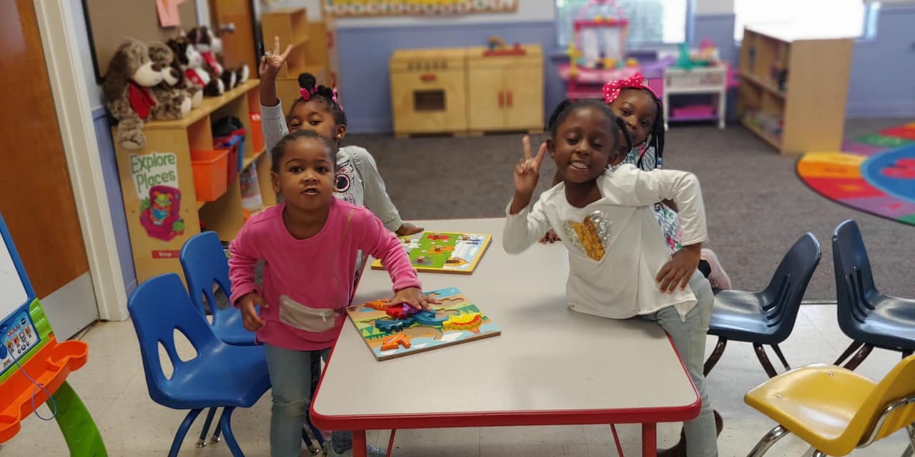 Children in a classroom, one making a peace sign