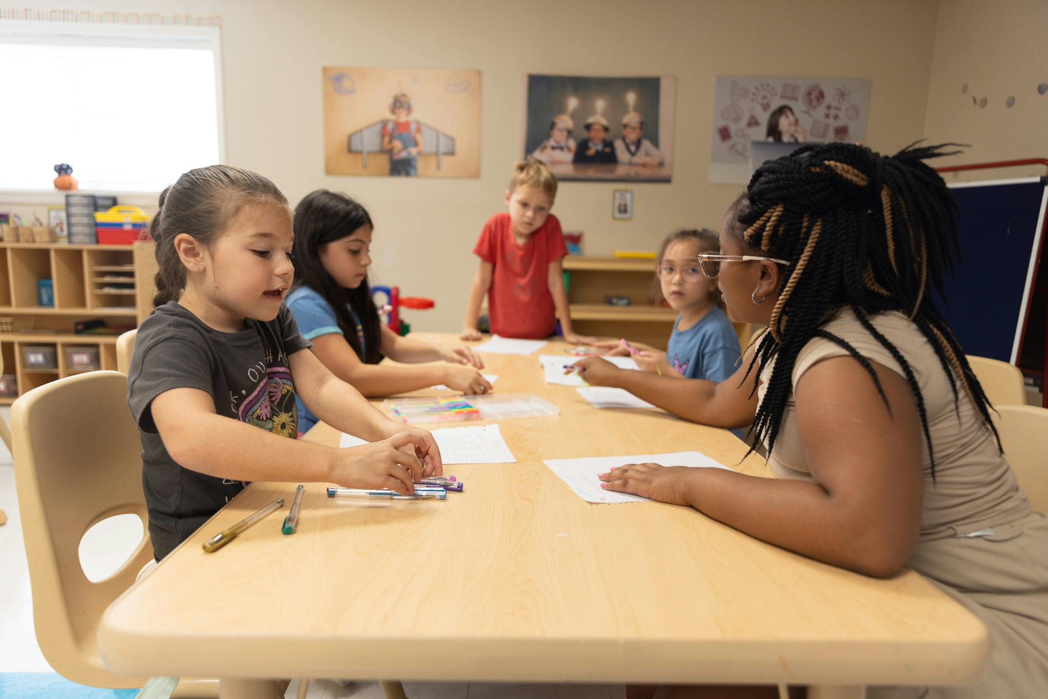 Adult and children sitting at a table in a classroom