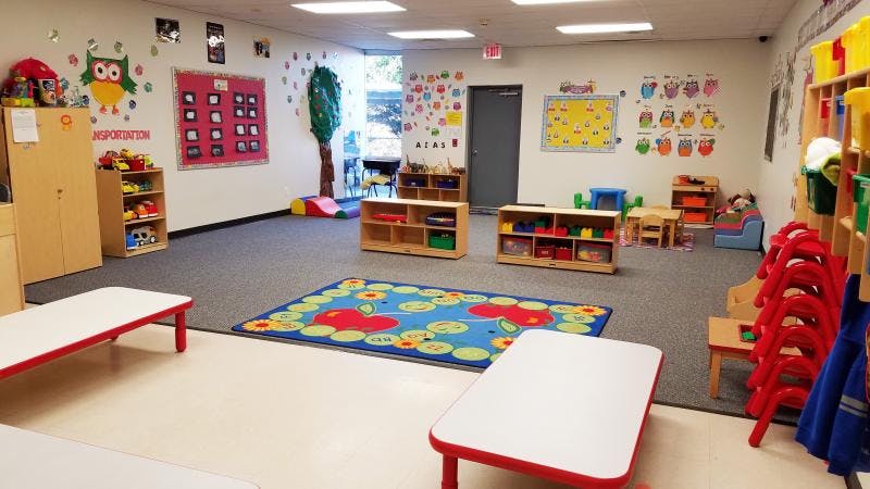 Empty classroom with small tables, chairs, and colorful decorations