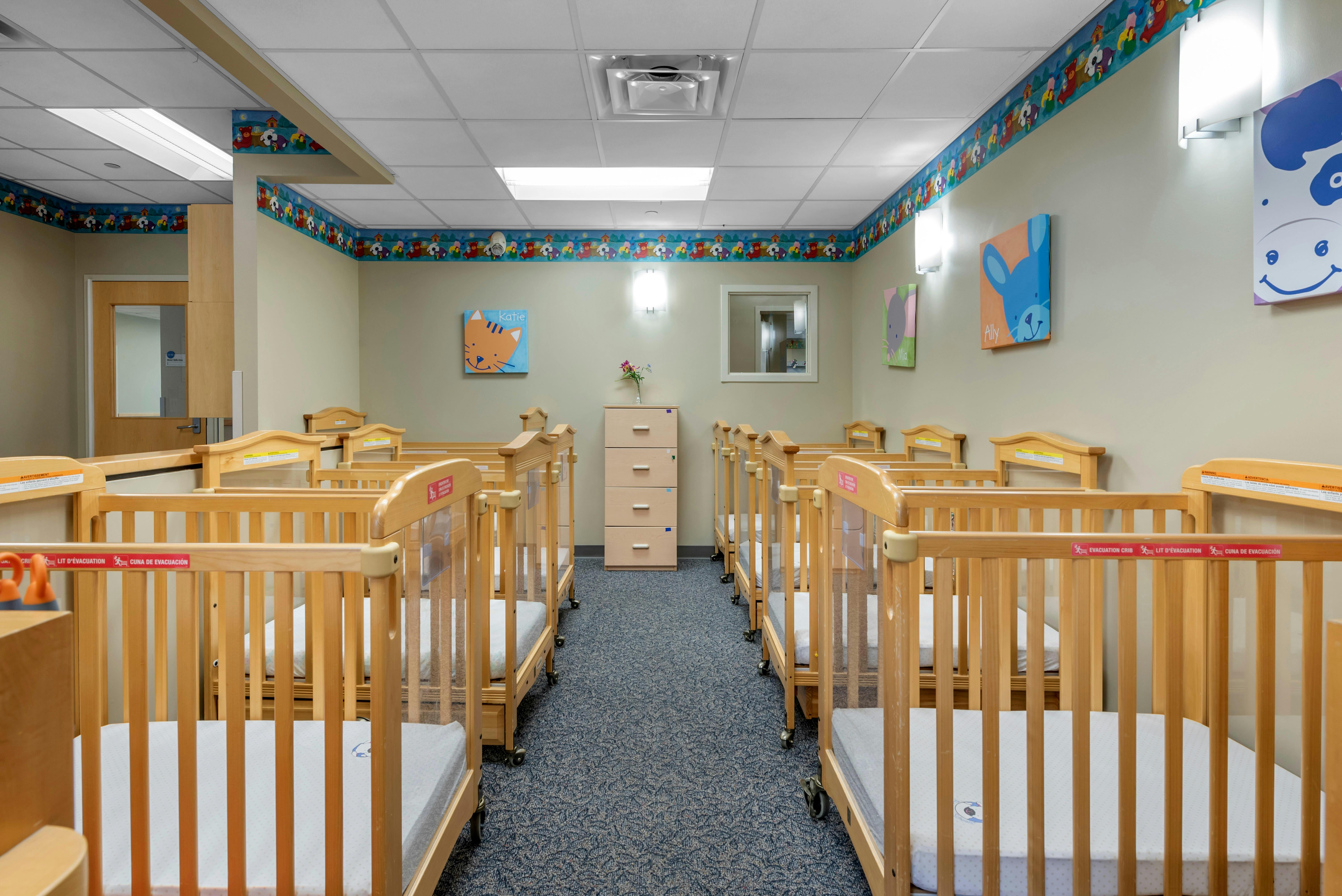 Rows of wooden cribs in a daycare room