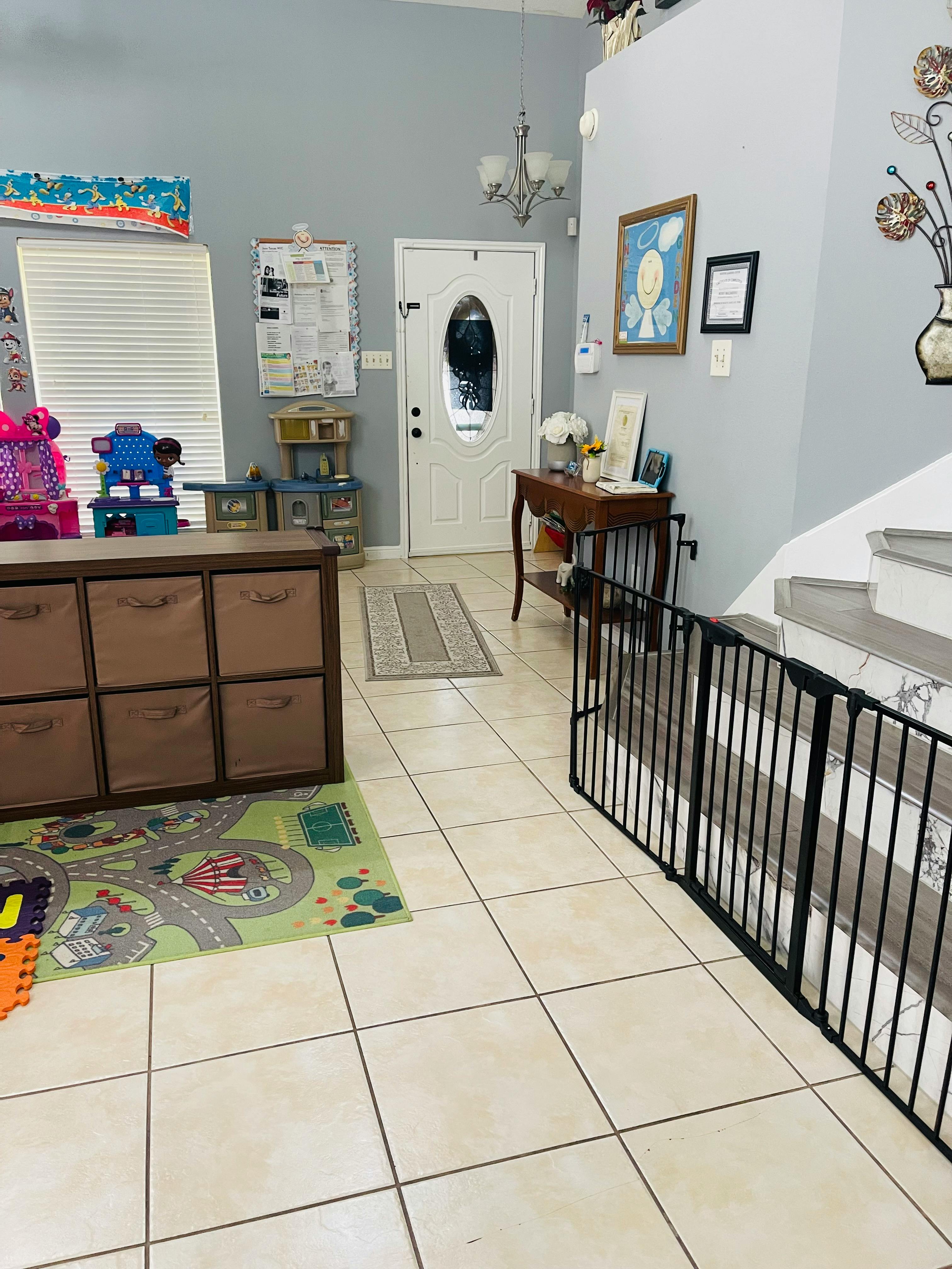 Entryway with a white door, storage unit, and baby gate