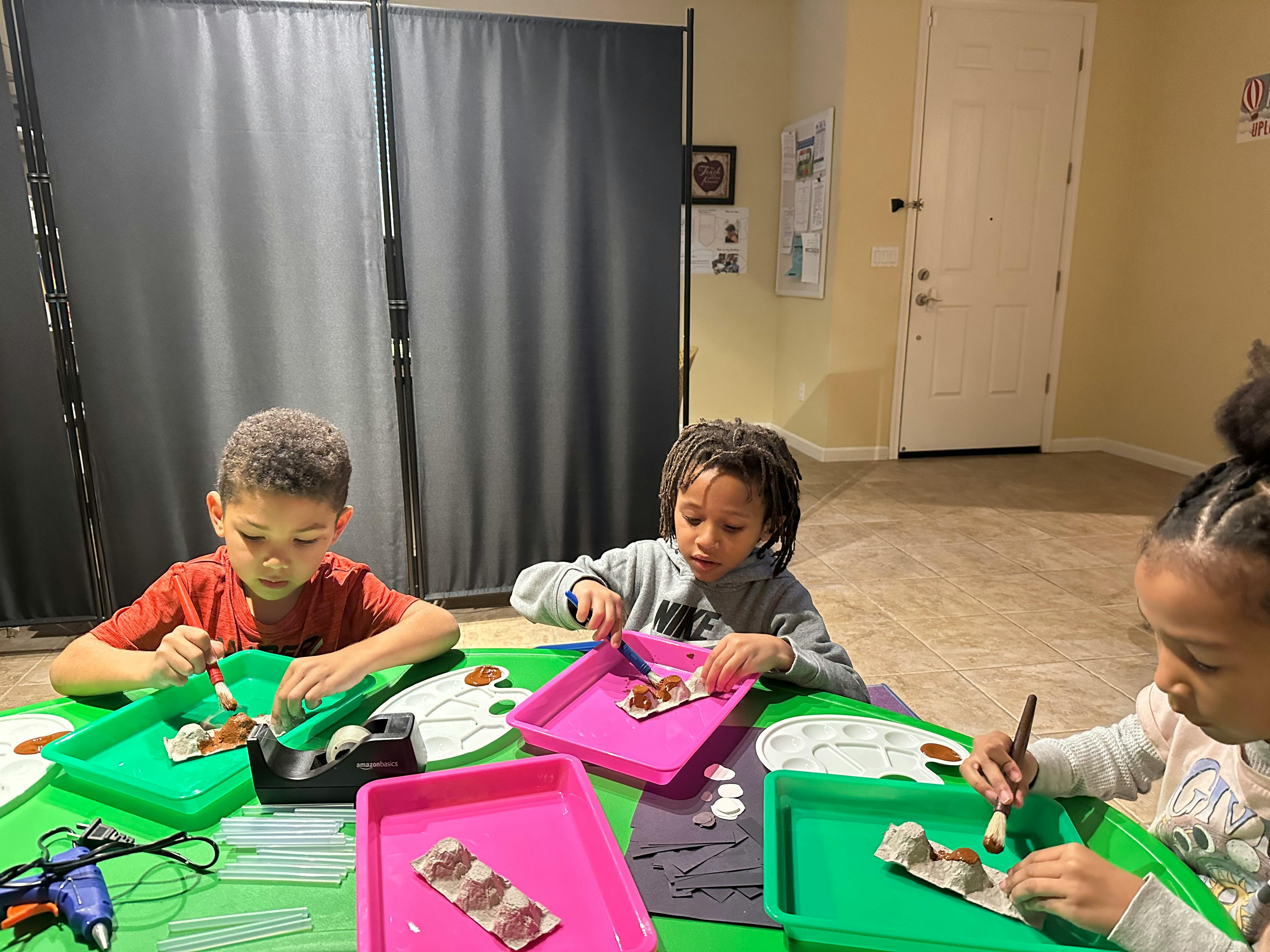 Three children doing crafts at a table