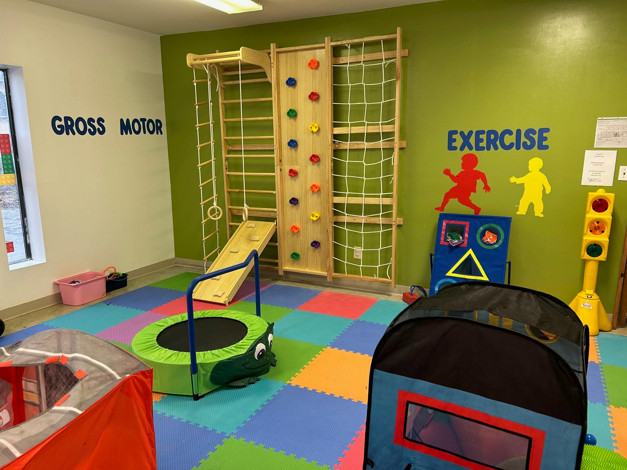 Indoor play area with climbing wall, slide, and trampoline