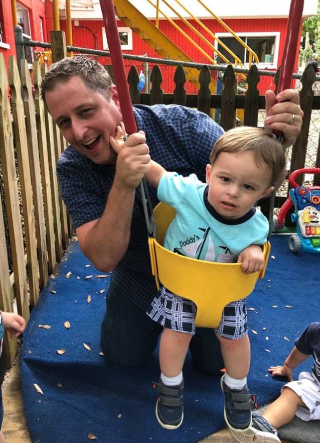 Person pushing a child in a swing