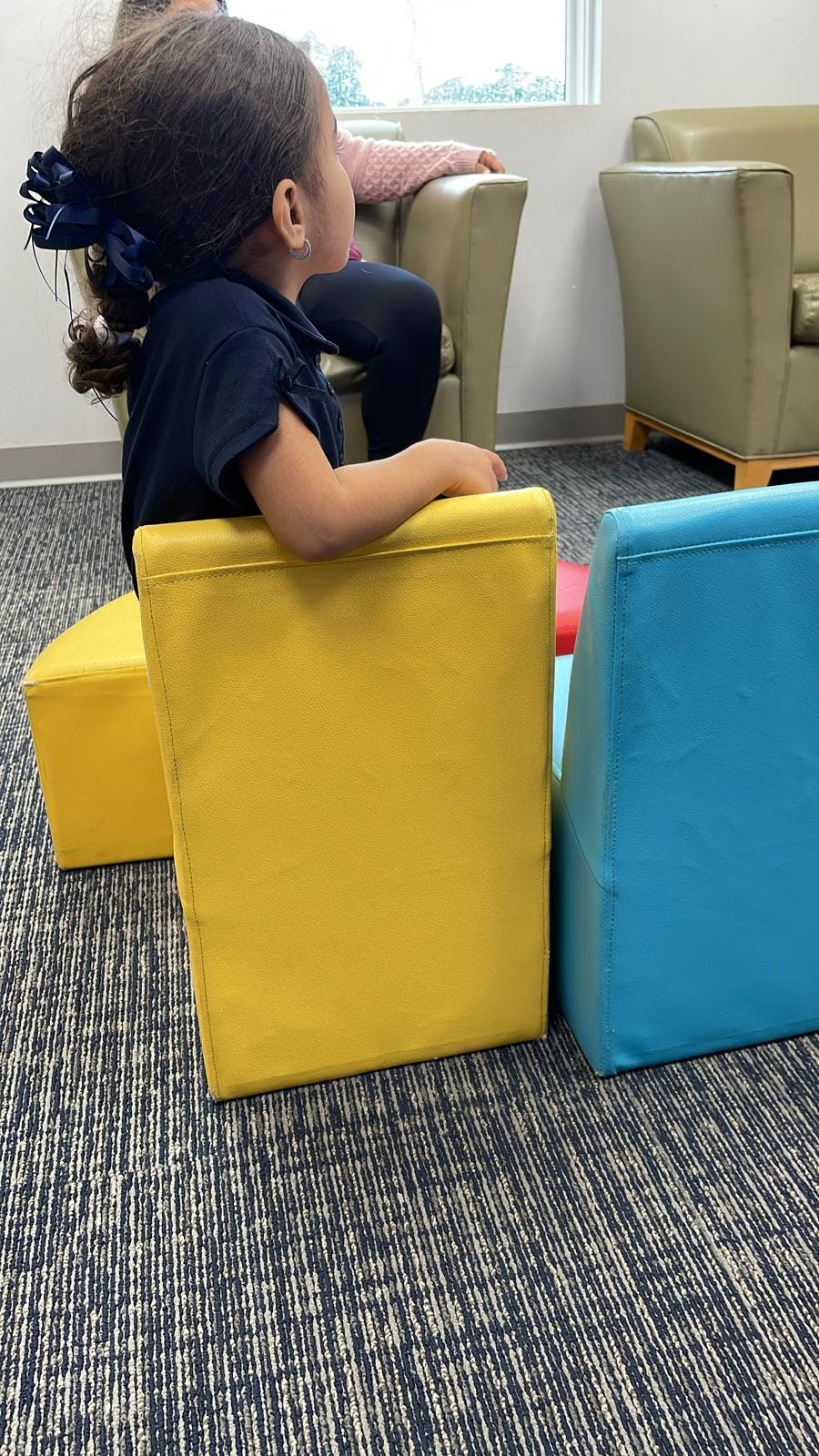 Child sitting on a yellow block chair