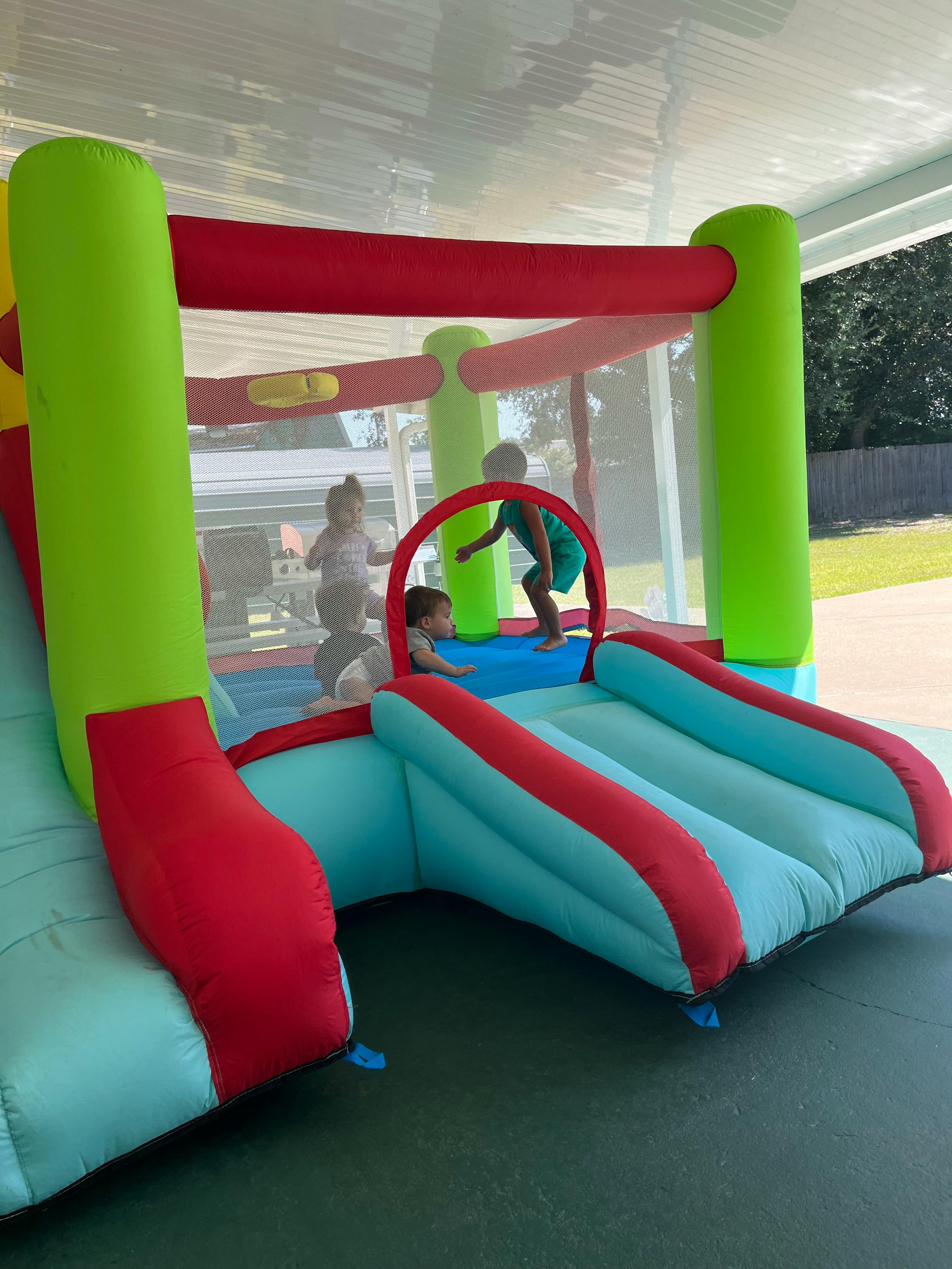 Children playing in an inflatable bounce house with a slide