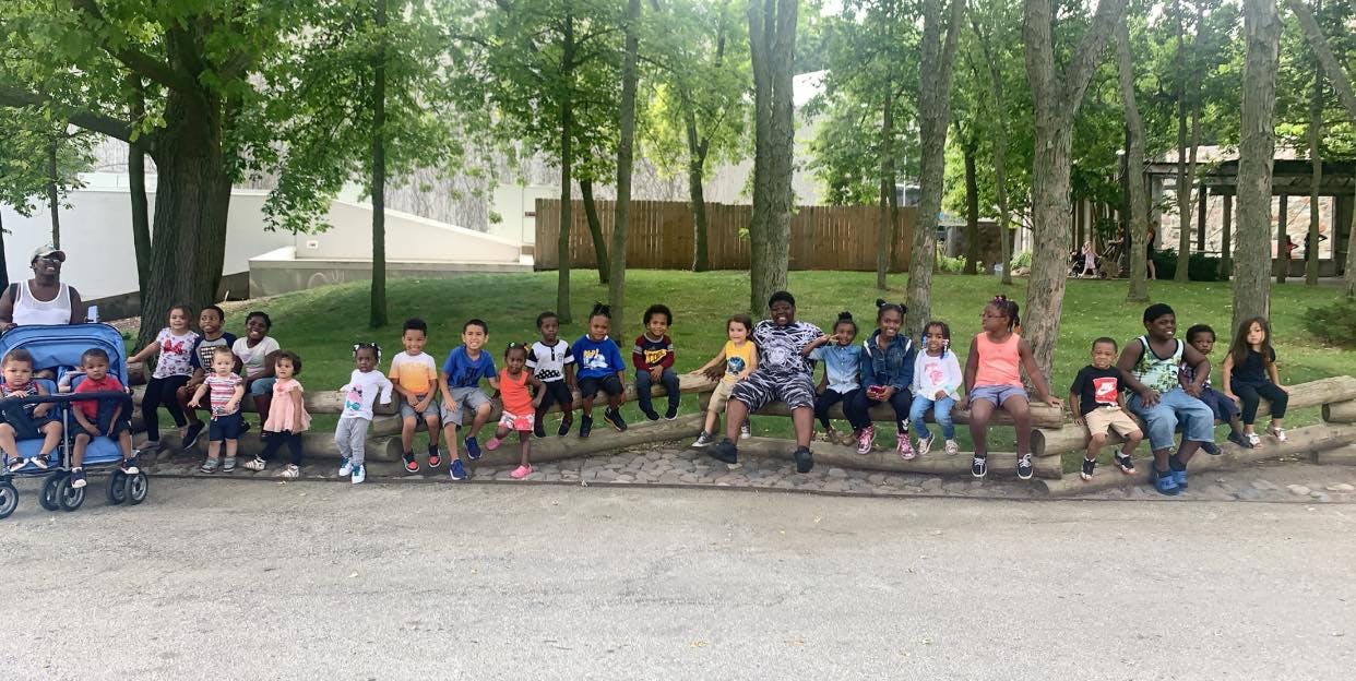 Group of children and adults sitting outdoors