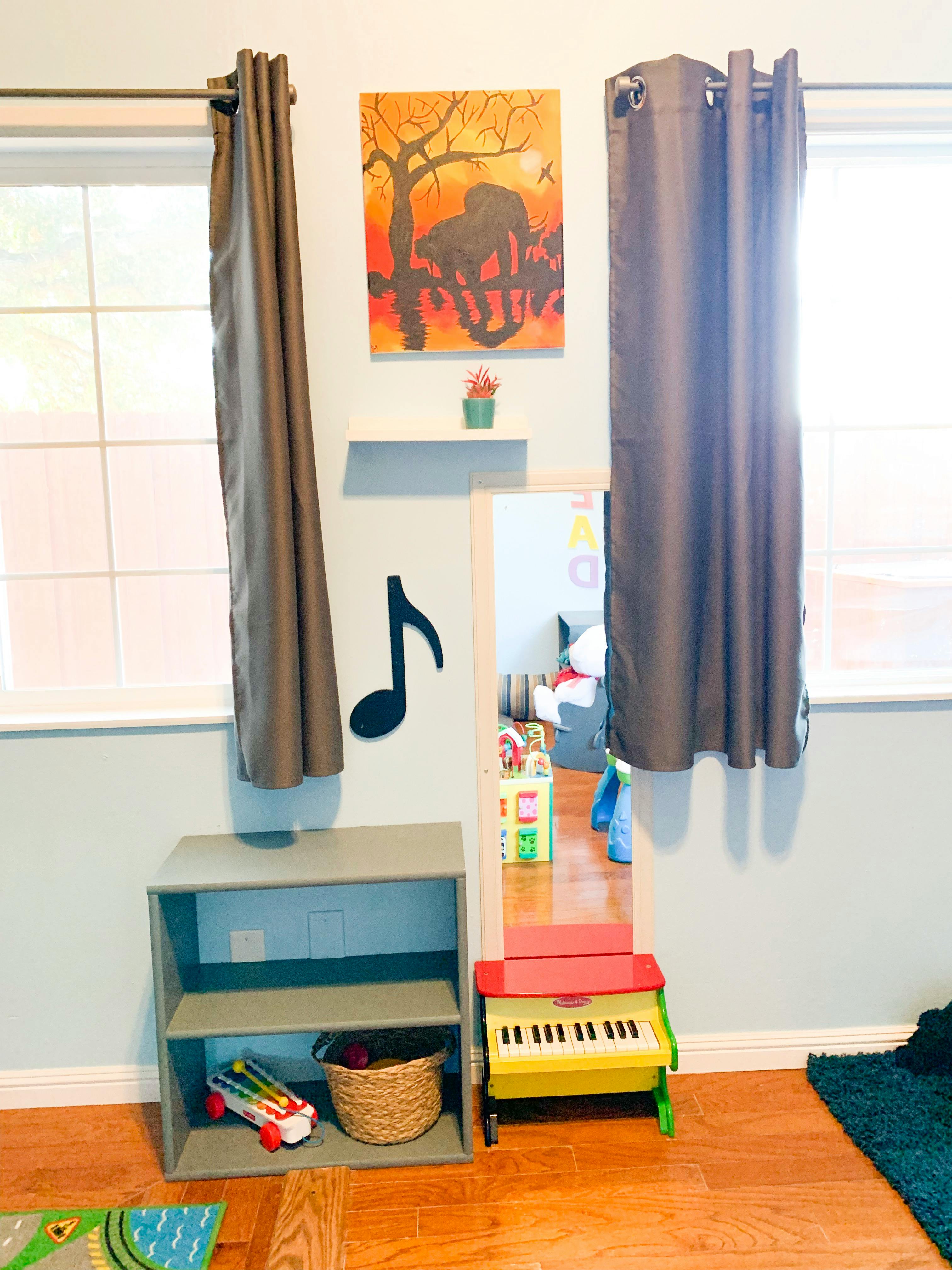 A room with a small bookshelf, a toy piano, and a musical note decoration