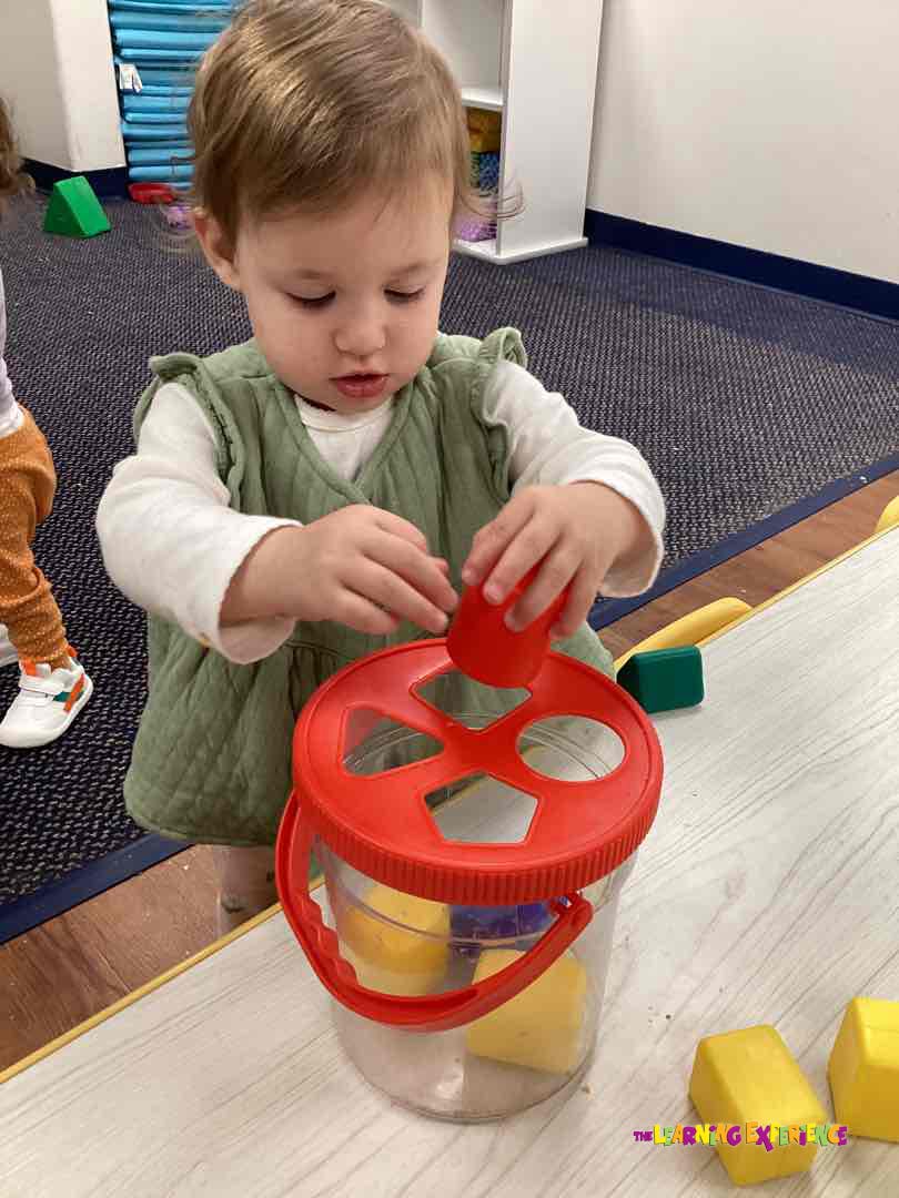 Child playing with a shape sorter toy