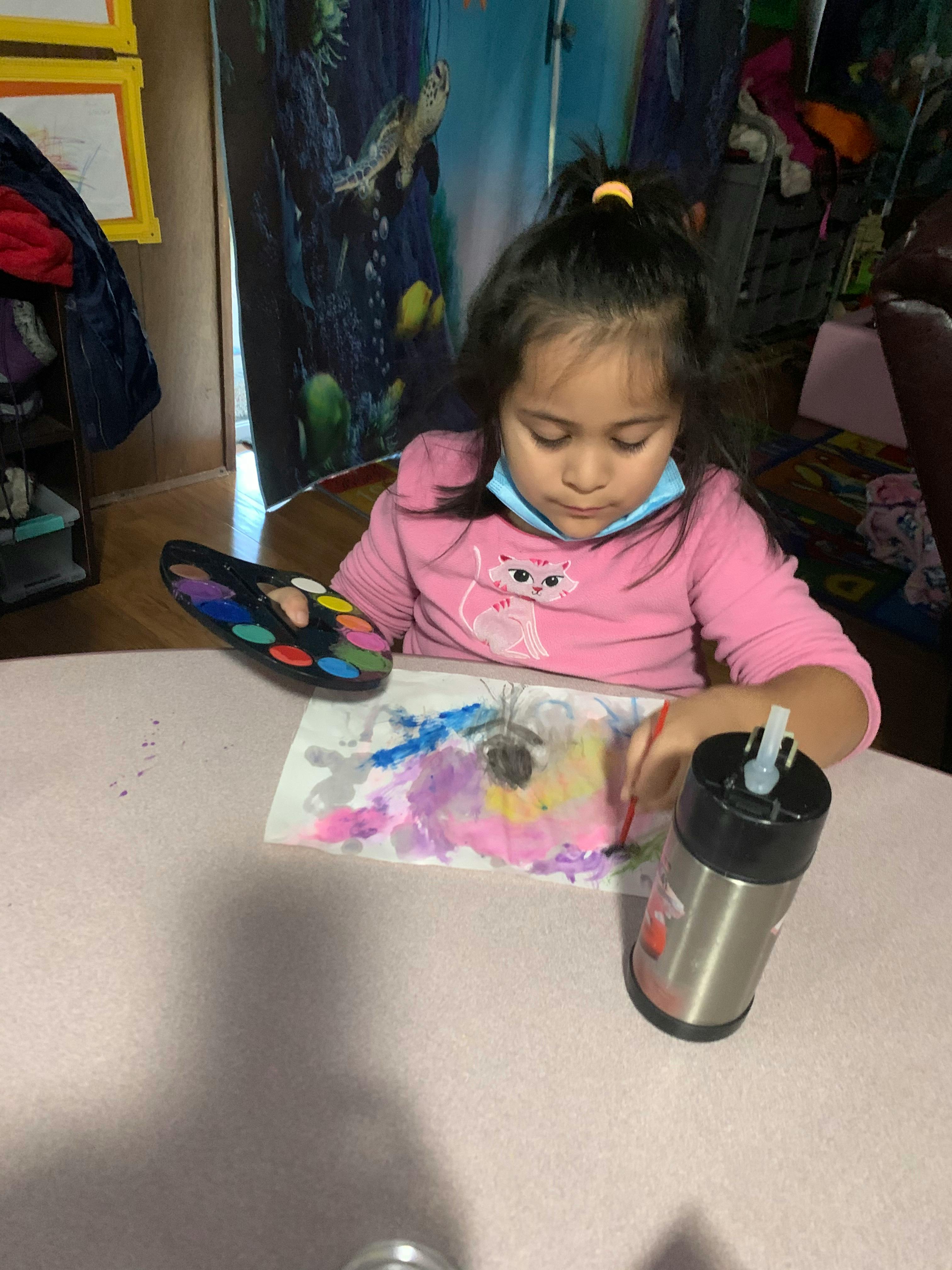 Child painting with watercolors at a table