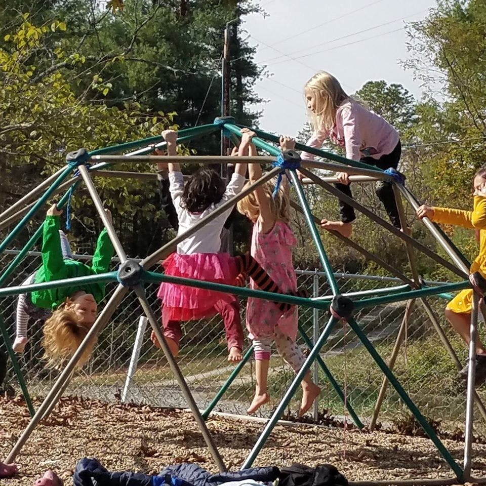 Children climbing on a geodesic dome playground structure
