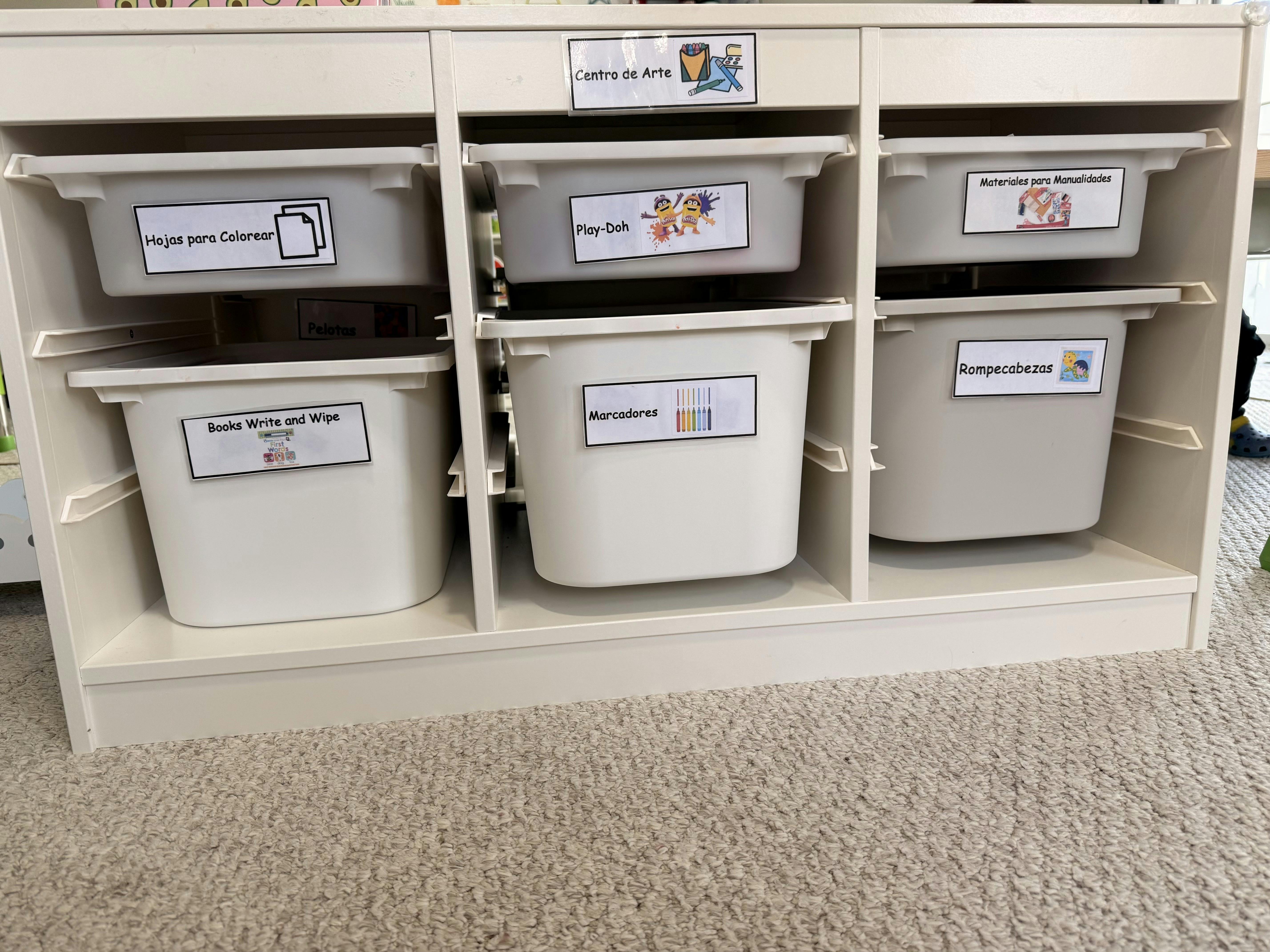 White storage bins with labels including "Hojas para Colorear" and "Play-Doh"