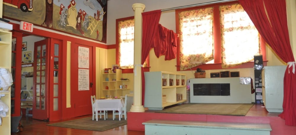 Playroom with red walls, yellow trim, and small furniture