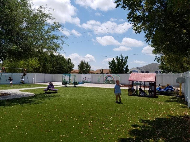 Children playing on an outdoor playground with artificial turf
