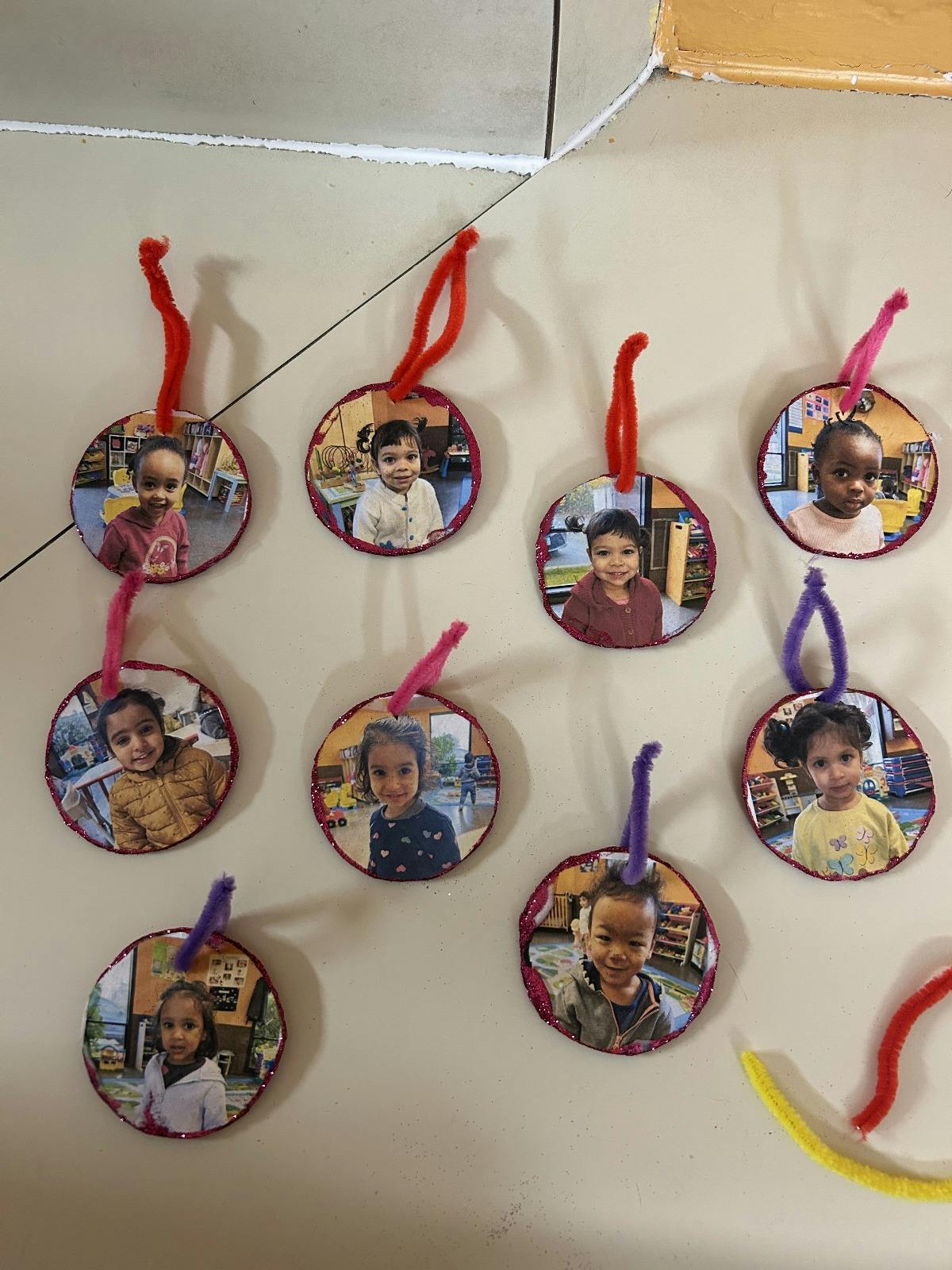 Nine circular ornaments with photos of children, some with red or purple loops