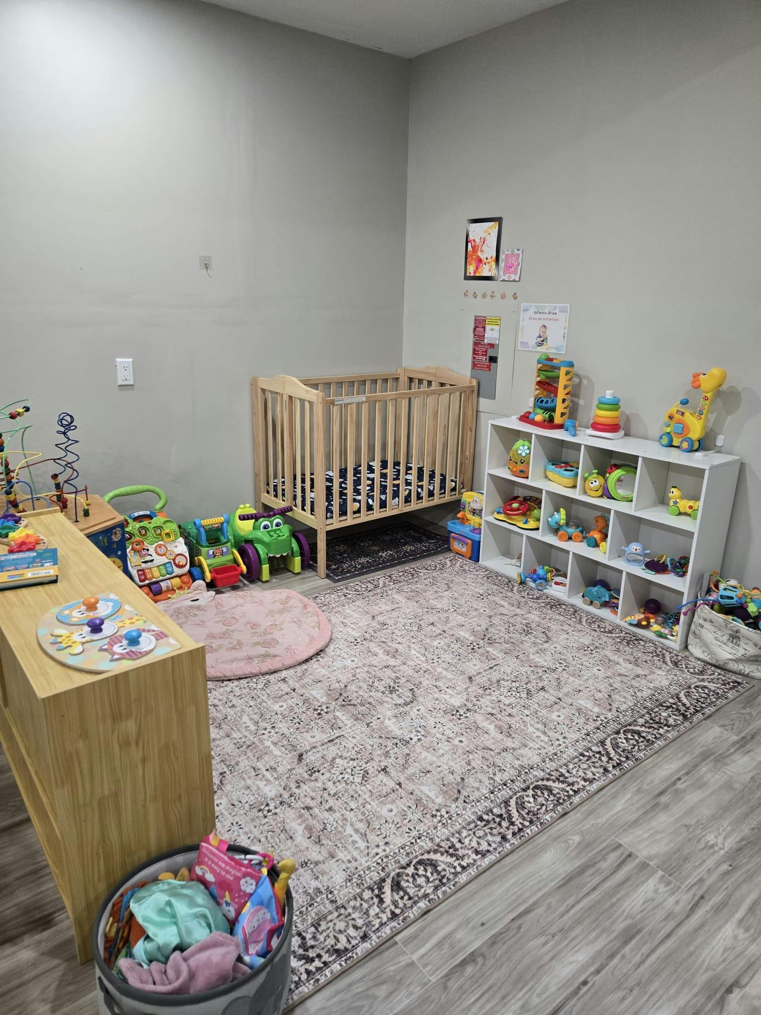 Nursery room with a crib, toy shelf, and play mat
