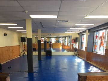 Empty gym with blue mats and mirrors