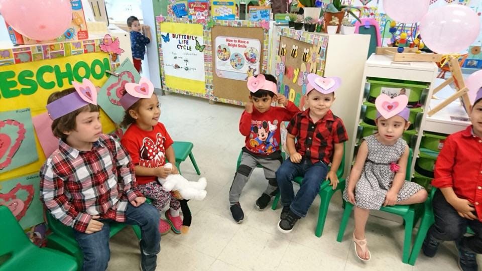 Children wearing heart headbands sitting in a classroom