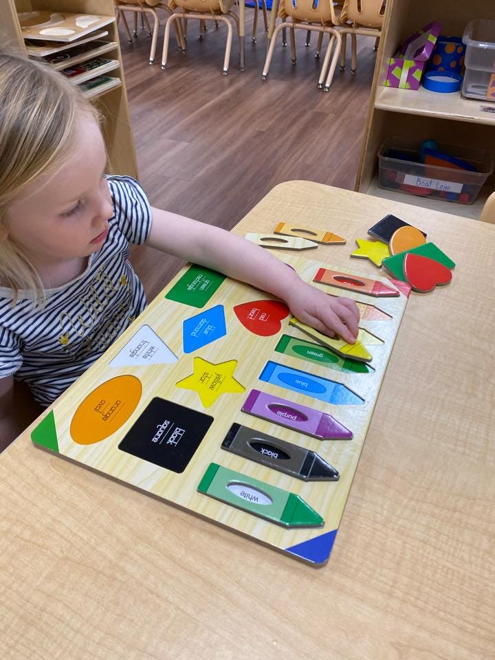 Child playing with a shape and color puzzle