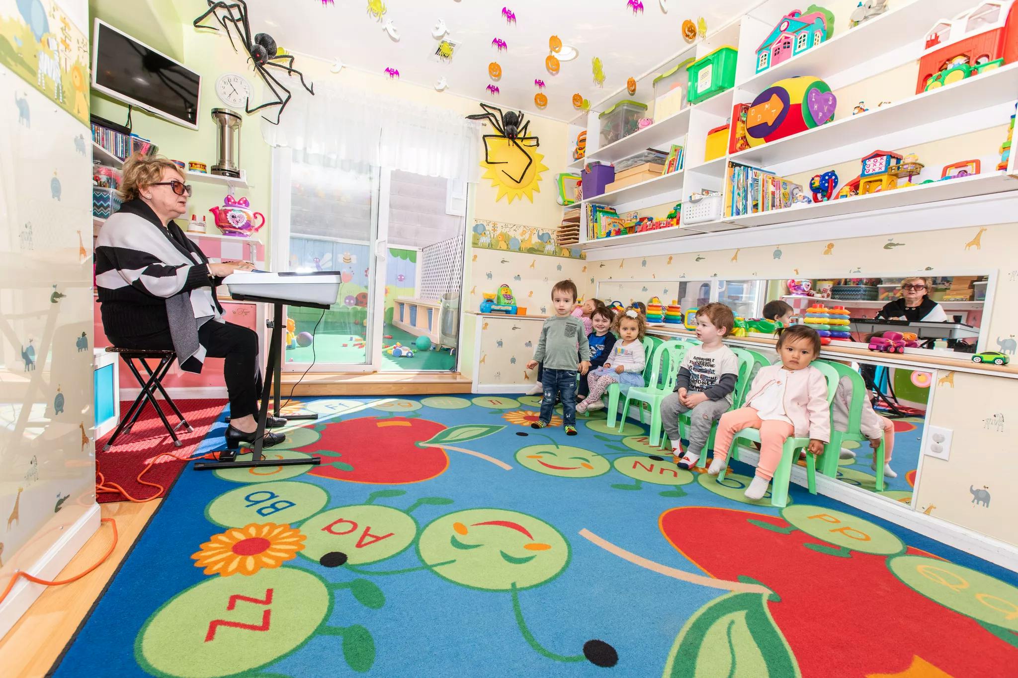 Person playing keyboard for children in a classroom