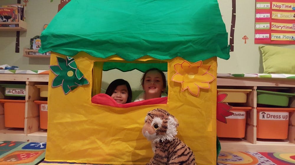 Two children looking out from a playhouse