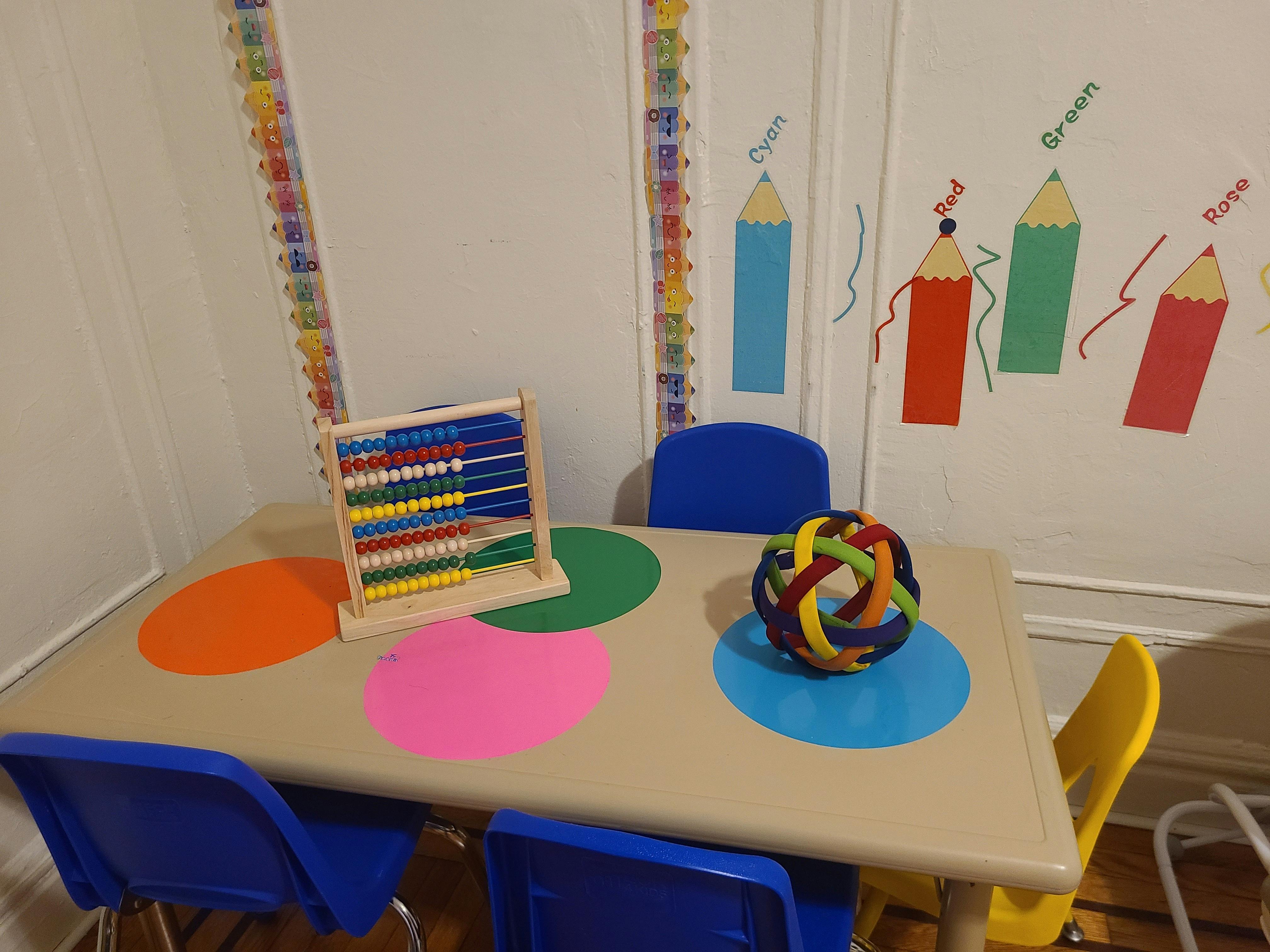 Abacus and colorful ball on a table with chairs in a classroom