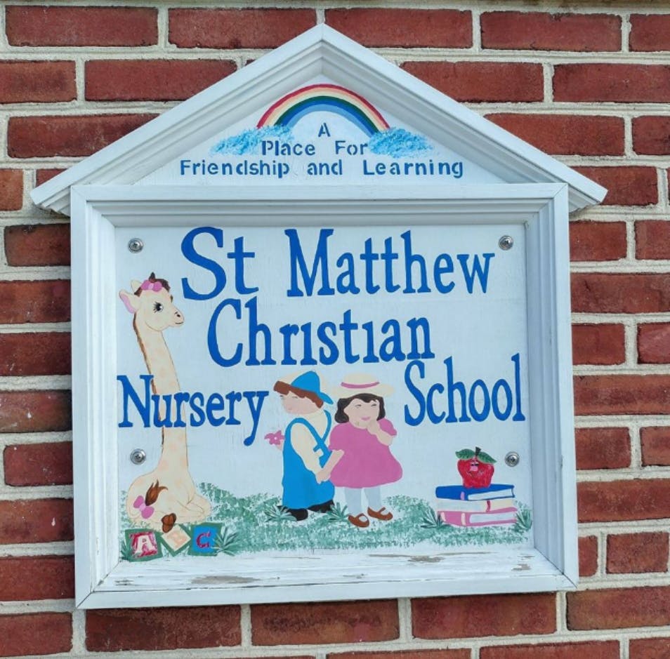 St Matthew Christian Nursery School sign with children and giraffe illustrations