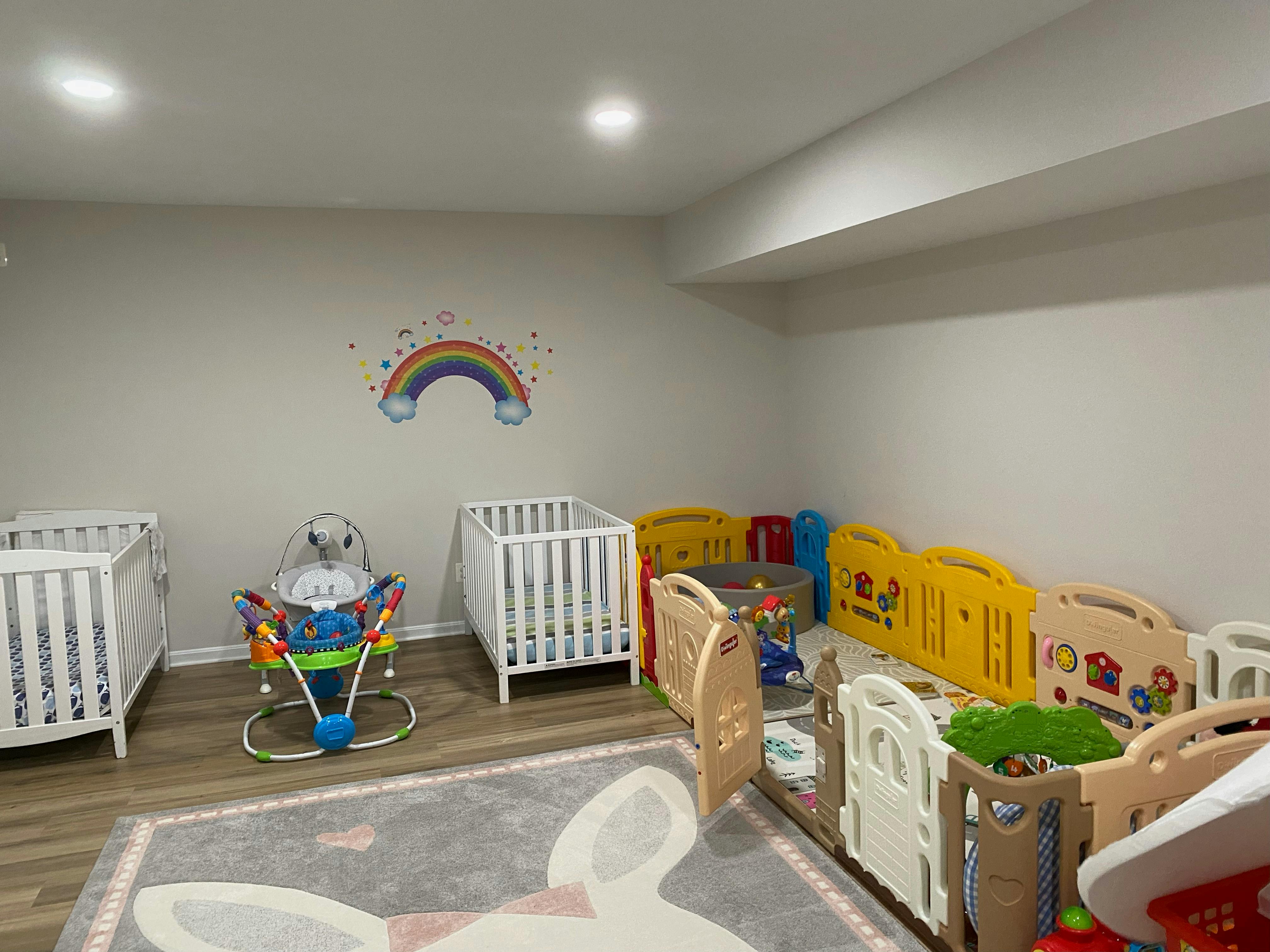Room with two cribs, a baby bouncer, and playpens