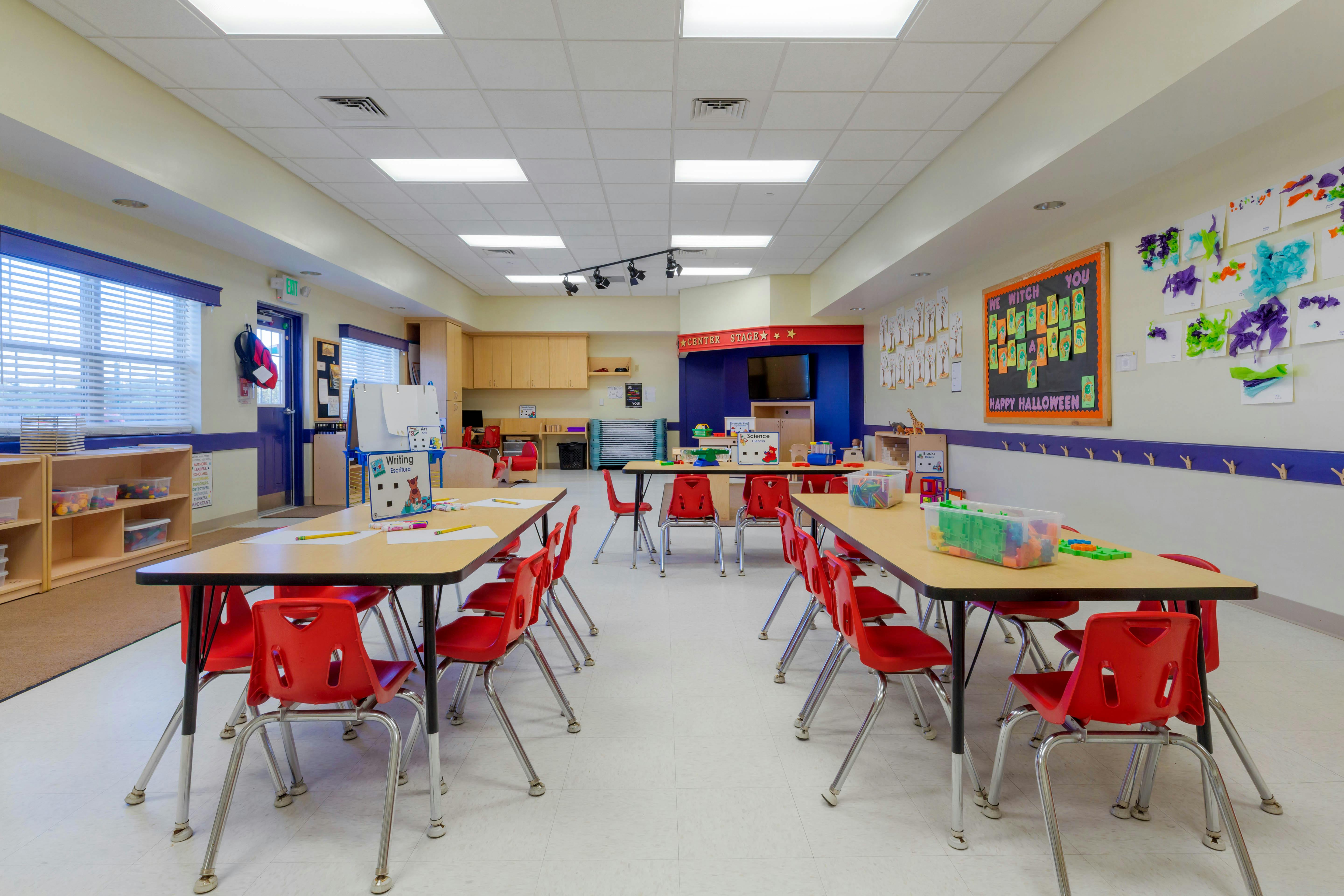 Classroom with child-sized tables and red chairs