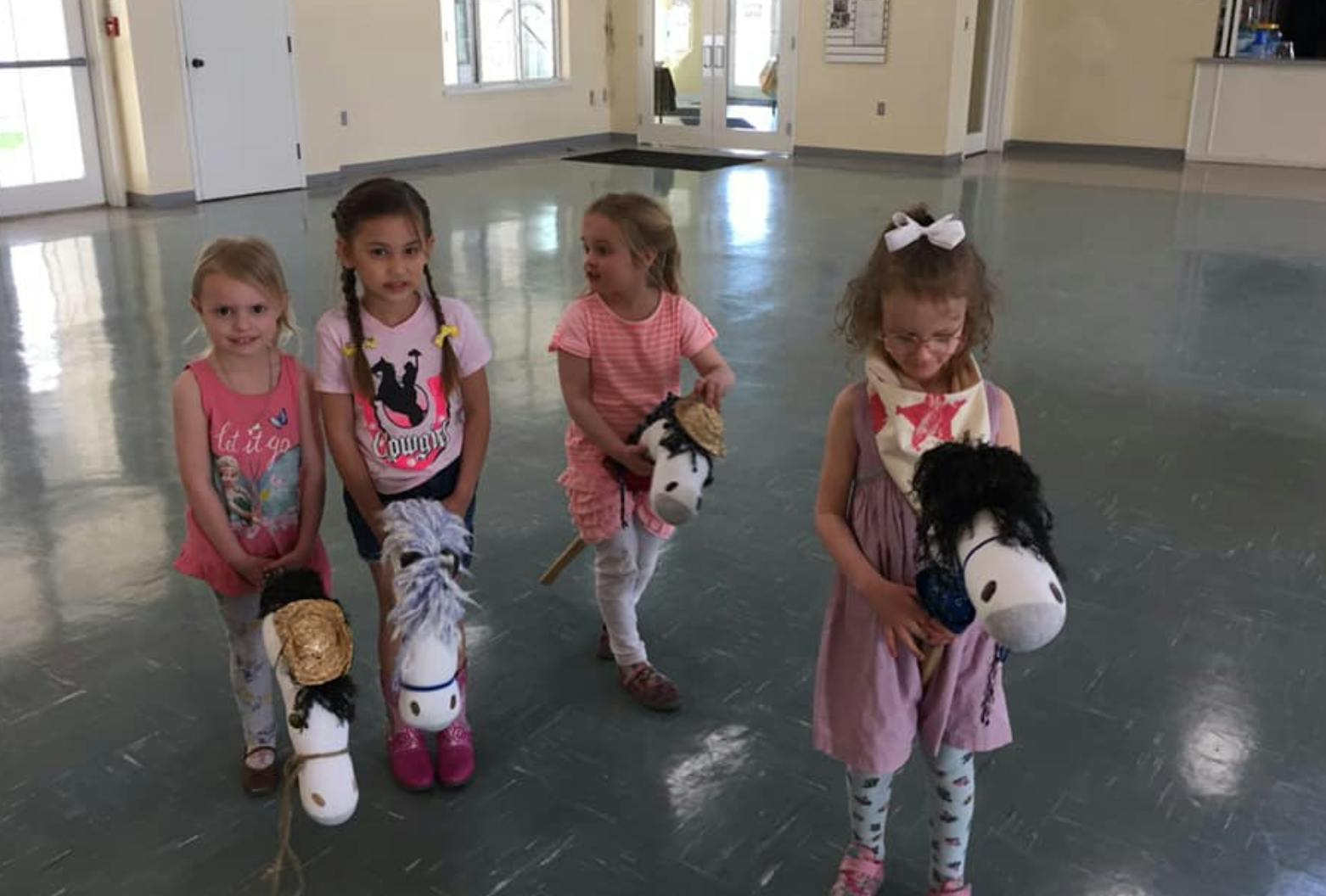 Four children holding hobby horses
