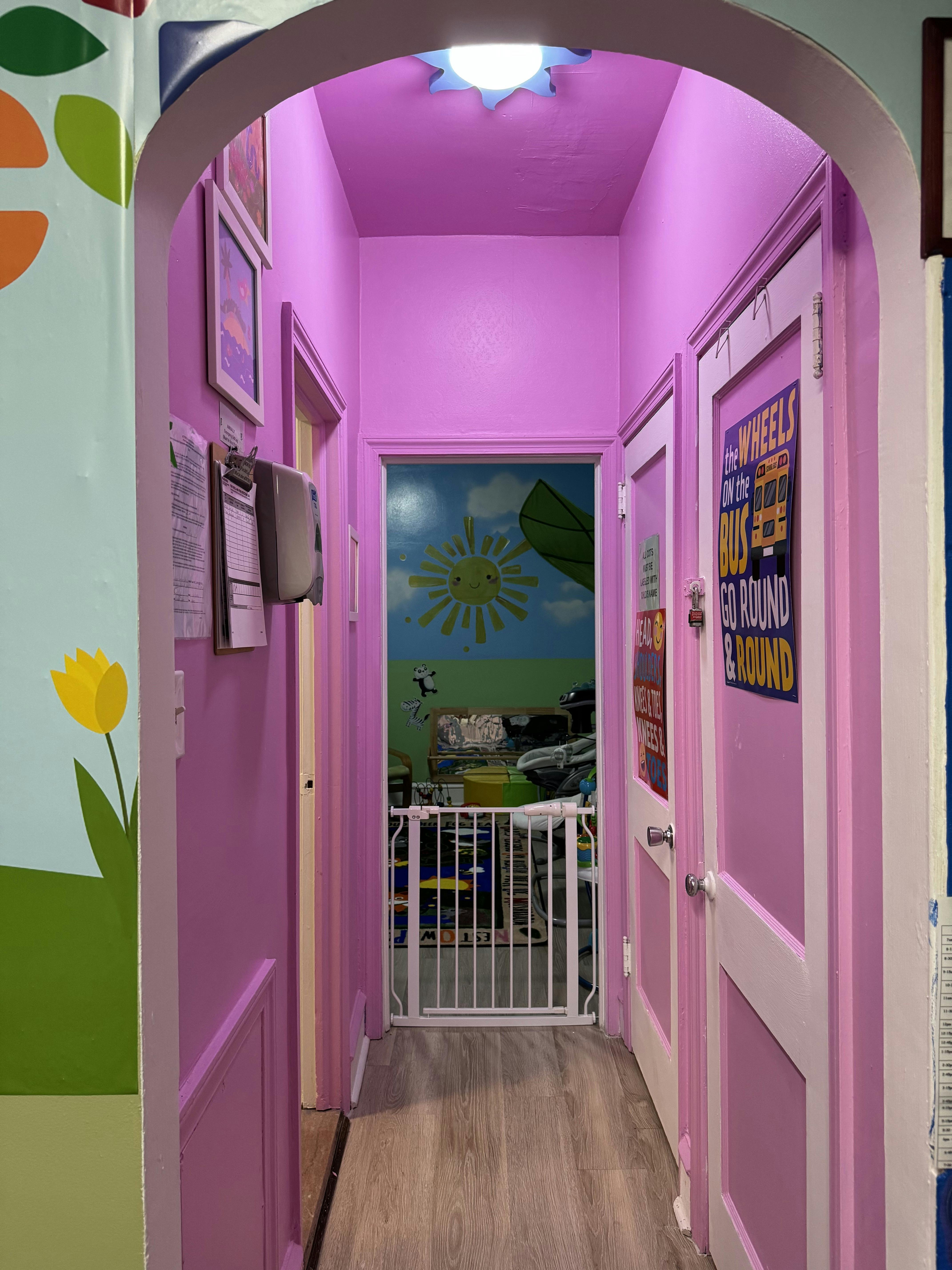 Hallway leading to a childcare room with a safety gate