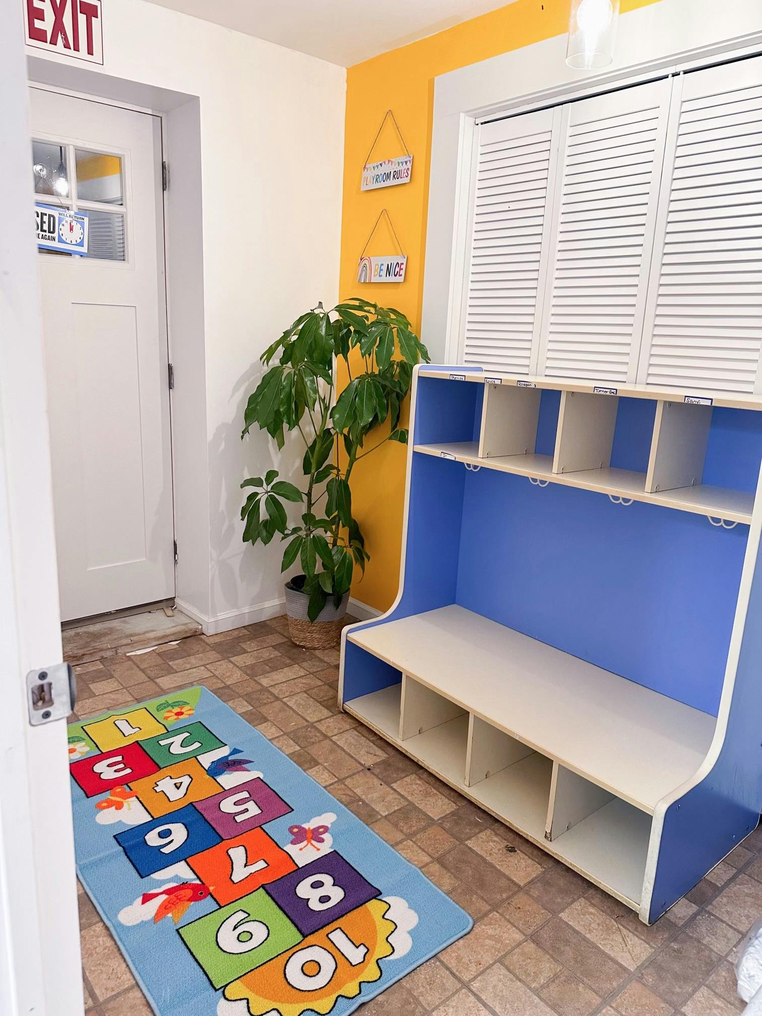 Hopscotch rug on floor next to blue and white storage unit