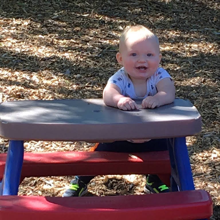 Child sitting at a small picnic table