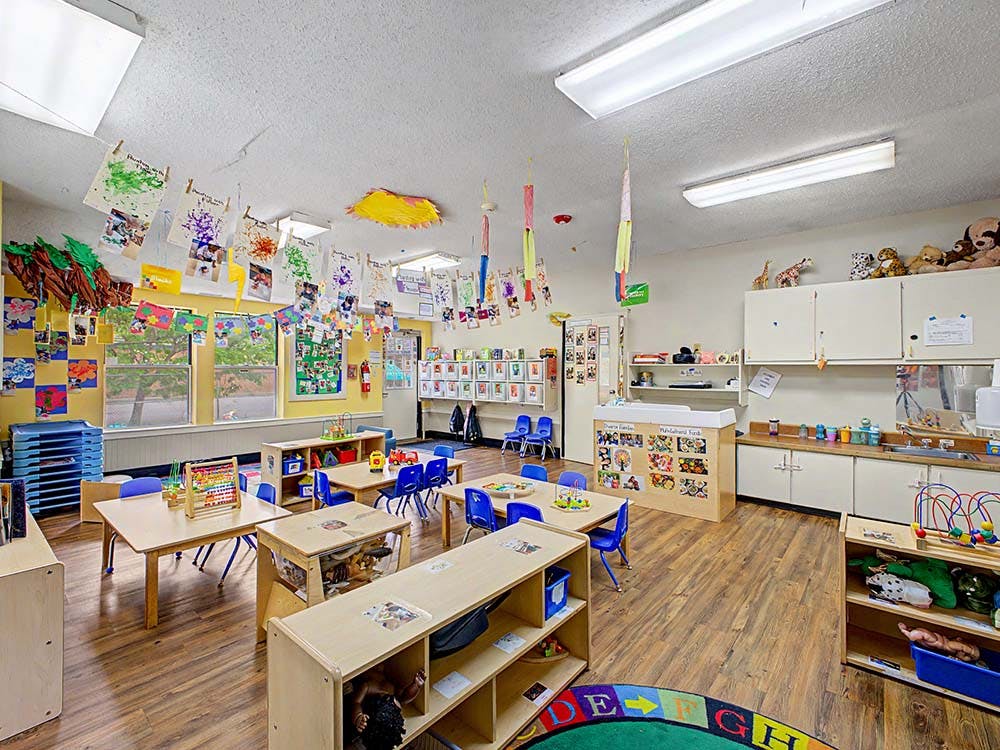Classroom with tables, chairs, and children's artwork