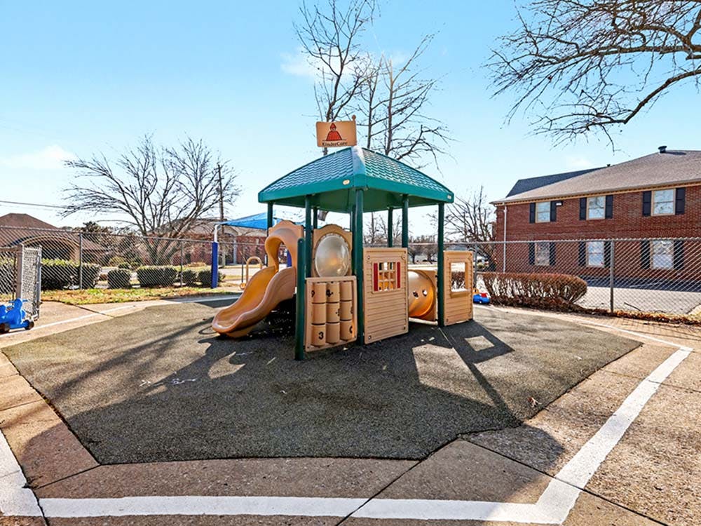 Empty outdoor playground with a slide and climbing structure