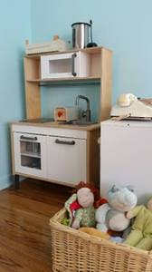 Toy kitchen with a basket of stuffed animals