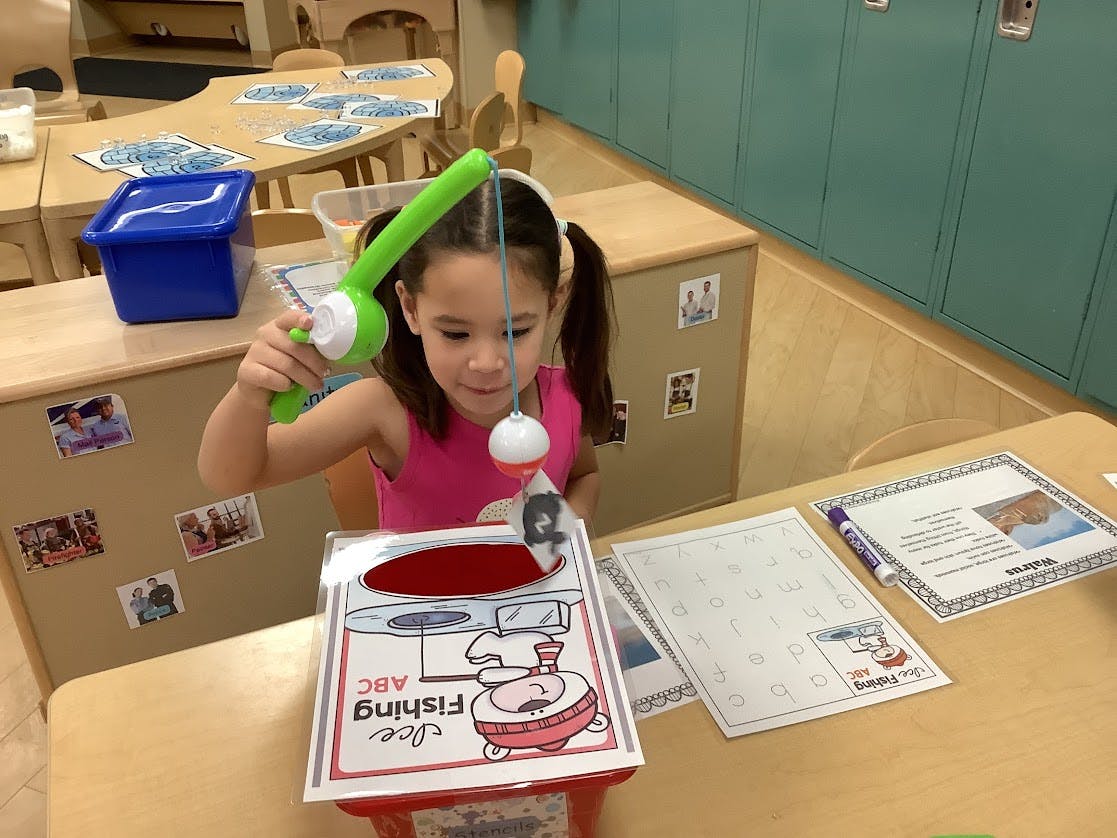 Child playing an ABC fishing game in a classroom
