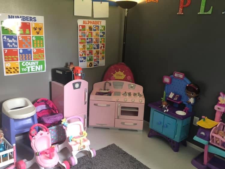 Playroom with toy kitchen, refrigerator, and alphabet and numbers charts