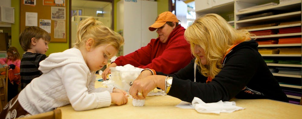 Adults and children at a table working on a craft